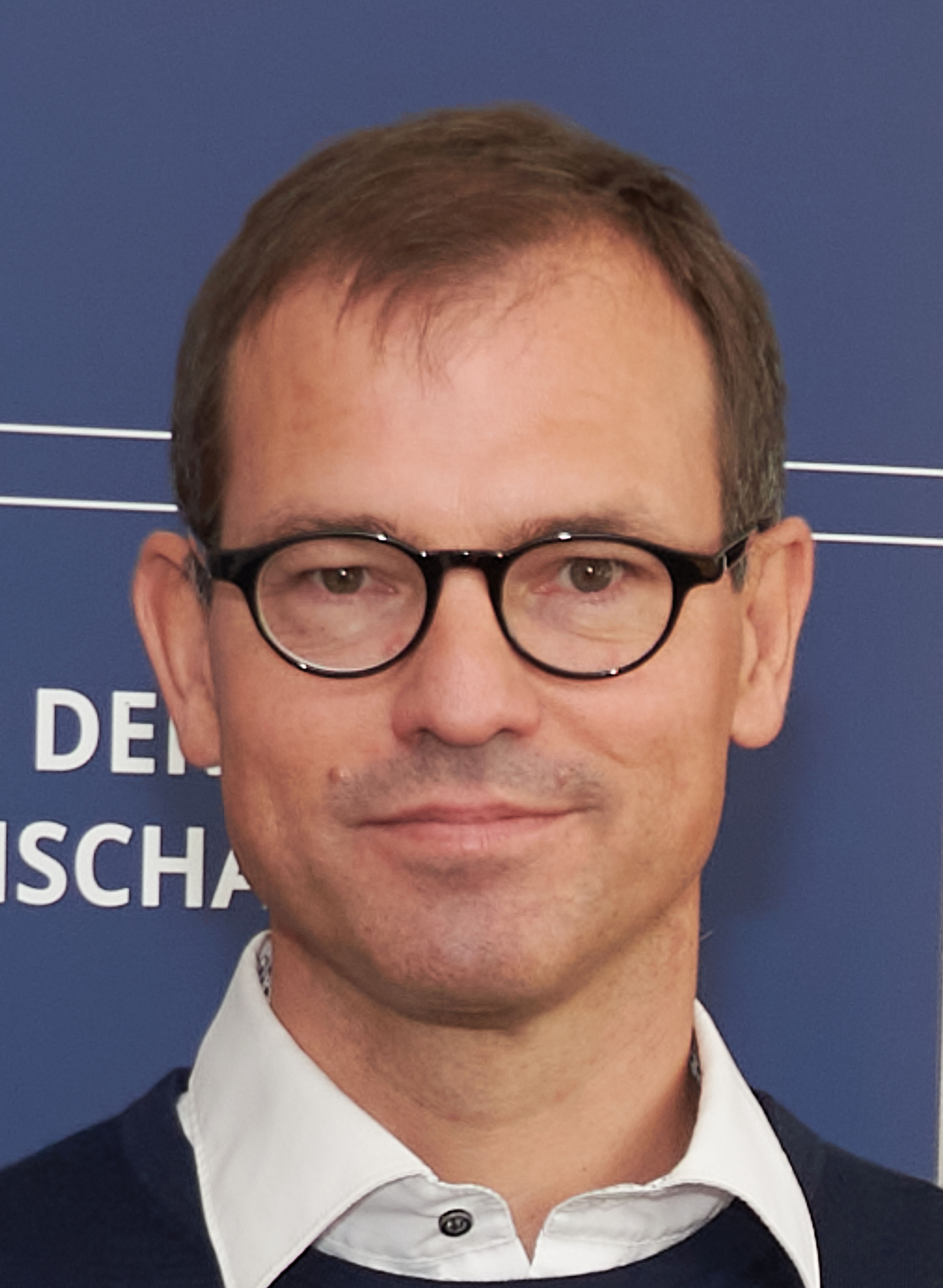 Portrait of a man with glasses and short brown hair