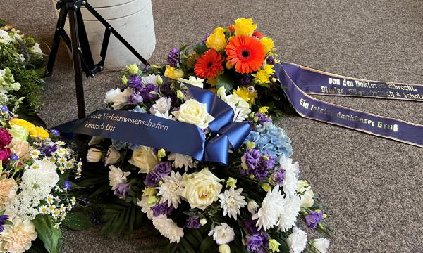 The picture shows a grave wreath with a bow.