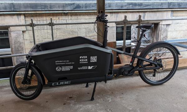 An e-cargo bike parked in front of a university building