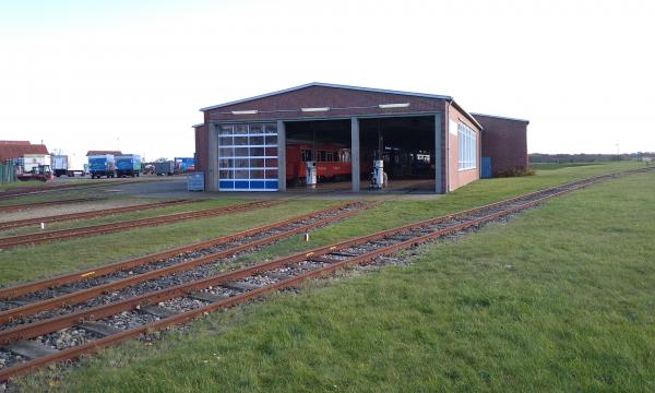 A hall with a railway wagon in it and a petrol pump.