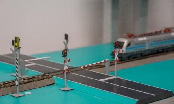 Model train passes a model railway crossing.