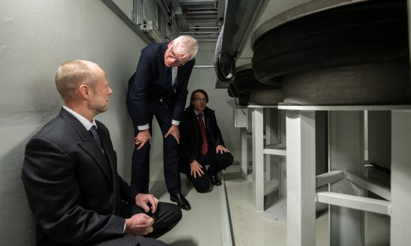 3 Männer schauen sich im Keller ein Schwingfundament an.