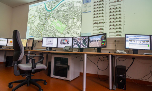  A traffic control centre with many monitors on tables and on the wall.