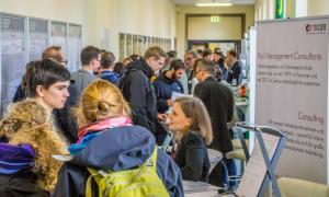 A corridor with exhibition stands and many people