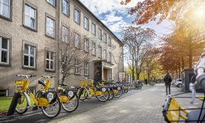 Exterior view of a TUD building with yellow rental bikes in front of it.