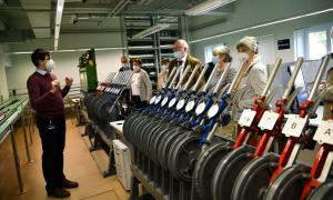 People in a railway laboratory. In the foreground, control levers.