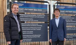 Welcoming Prof. Meng Wang (centre) to his new place of work: Prof. Günther Prokop (left) and Dr. Michael Krieg (right), Dean and Managing Director of the Faculty of Transport and Traffic Sciences Three men standing in front of a signpost board at TU Dresden