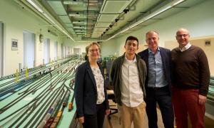 Eine Frau, ein Student und zwei Männer stehen im Eisenbahnlabor der TU Dresden