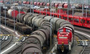 Ein Rangierbahnhof mit vielen Zügen mit Waggons. Eine Lok zieht einen Zug.