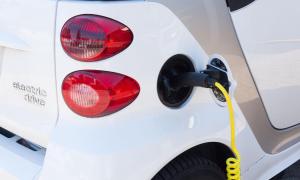 A small electric car refuelling at a charging station