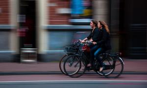 Zwei Frau auf Fahrrädern rollen durch die Stadt