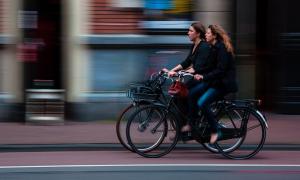 Two women cycling next to each other.