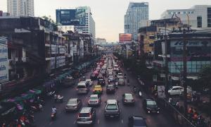 Urban canyons of a big city in India with traffic jams, cars, mopeds.