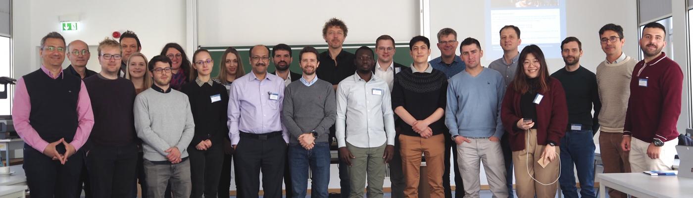 Ein Gruppenbild mit ca. 30 Personen in einem Seminarraum vor einer Tafel