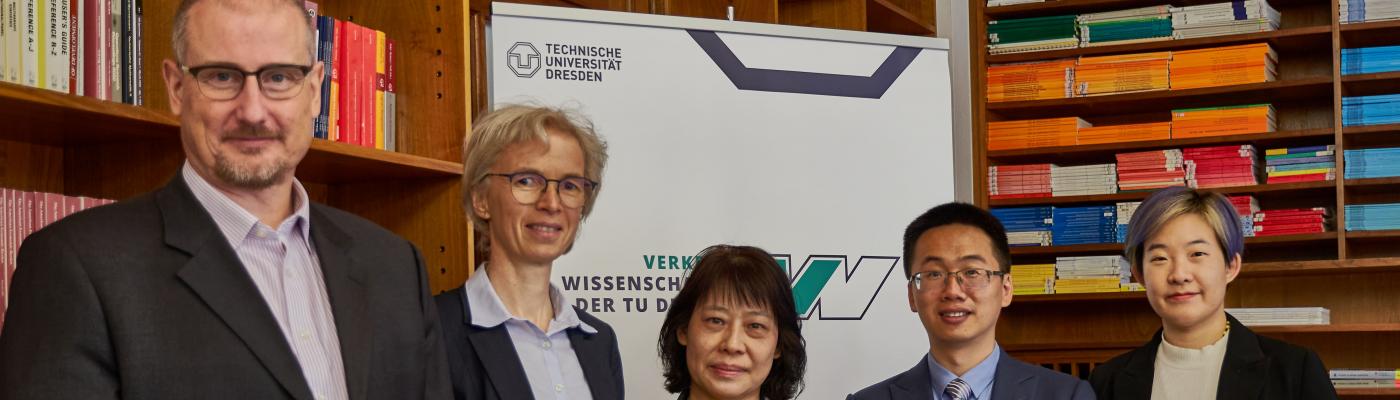 Zwei Männer und Drei Frauen vor dem Banner der Fakultät Verkehrswissenschaften