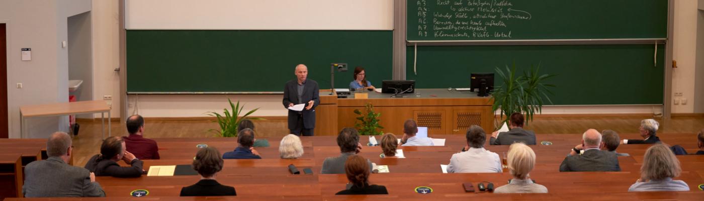 Ein Hörsaal mit Menschen sitzend in Abständen.