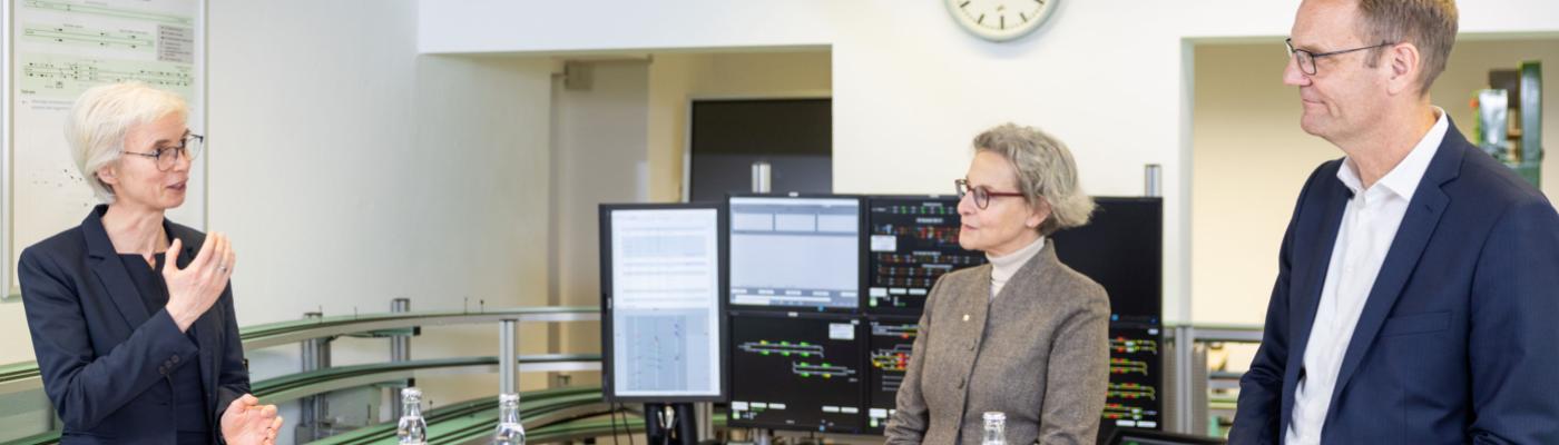 Two women and a man standing in a laboratory