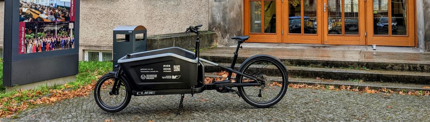 Ein E-Lastenrad geparkt vor einem Hochschulgebäude