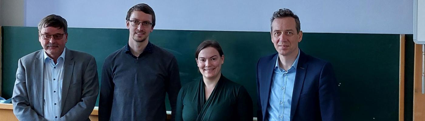 4 People standing in front of a board