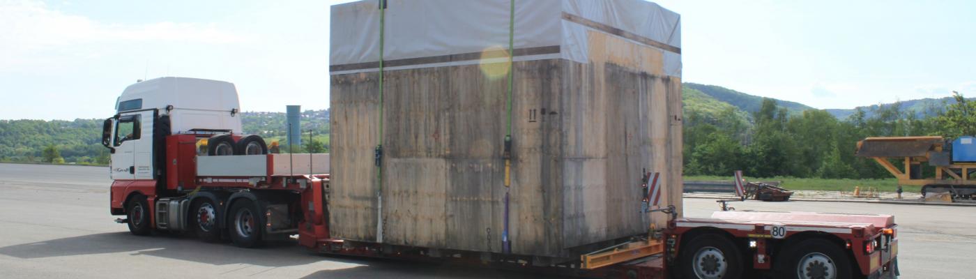 A truck with a large wooden box on the trailer