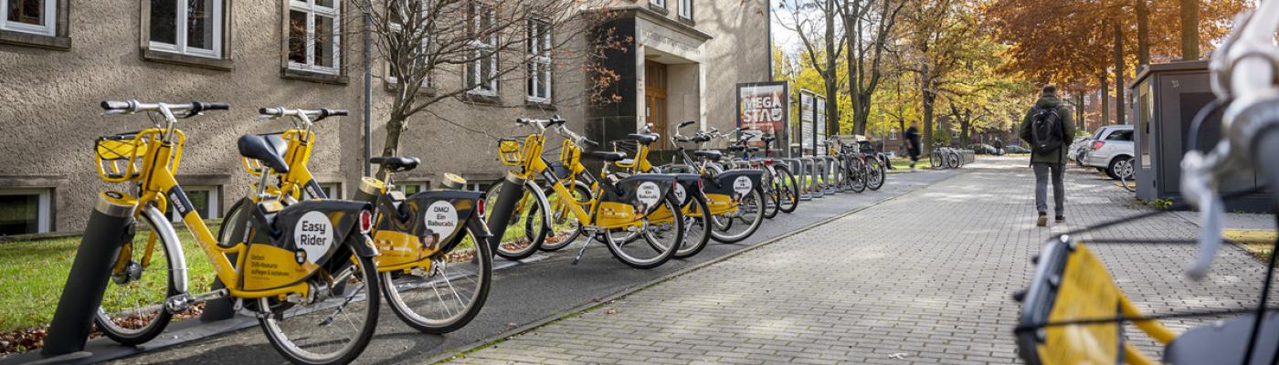 Exterior view of a TUD building with yellow rental bikes in front of it.