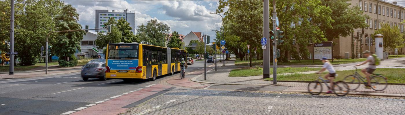 Straßenkreuzung mit Bushaltestelle und Radfahrenden