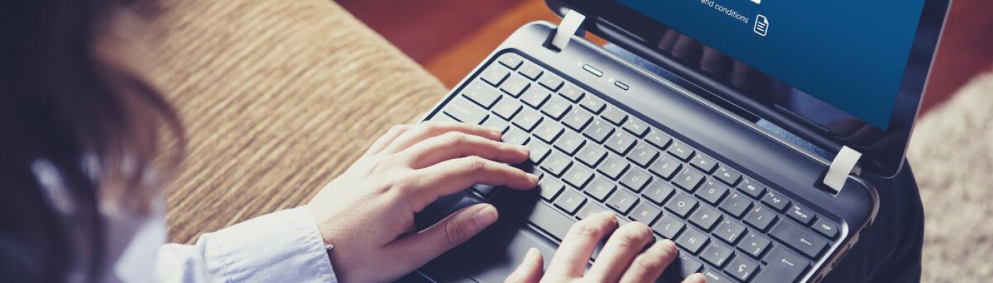 The photo shows a person with a laptop on her lap.