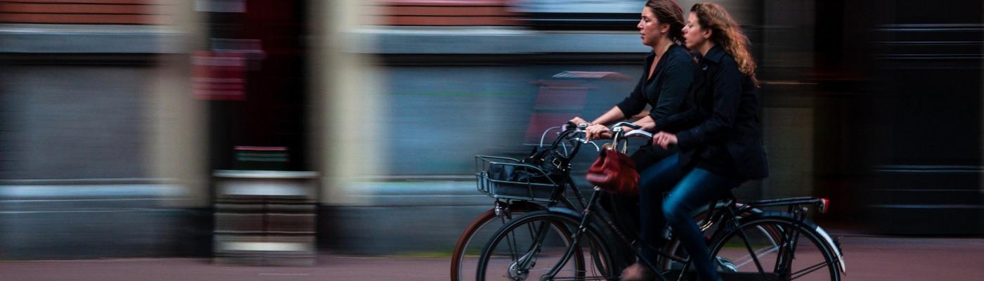 Two women cycling next to each other.